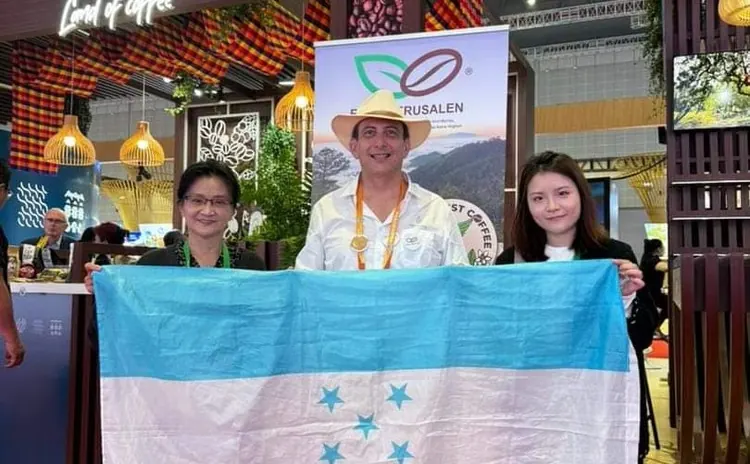 Equipo de APROCAJER con la bandera de Honduras en una feria